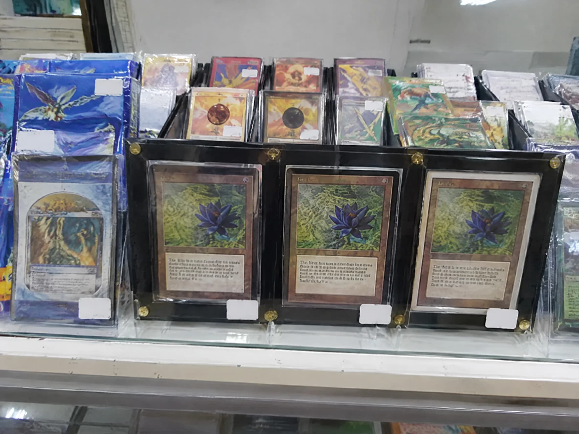A glass case of old sealed booster packs and framed cards.
