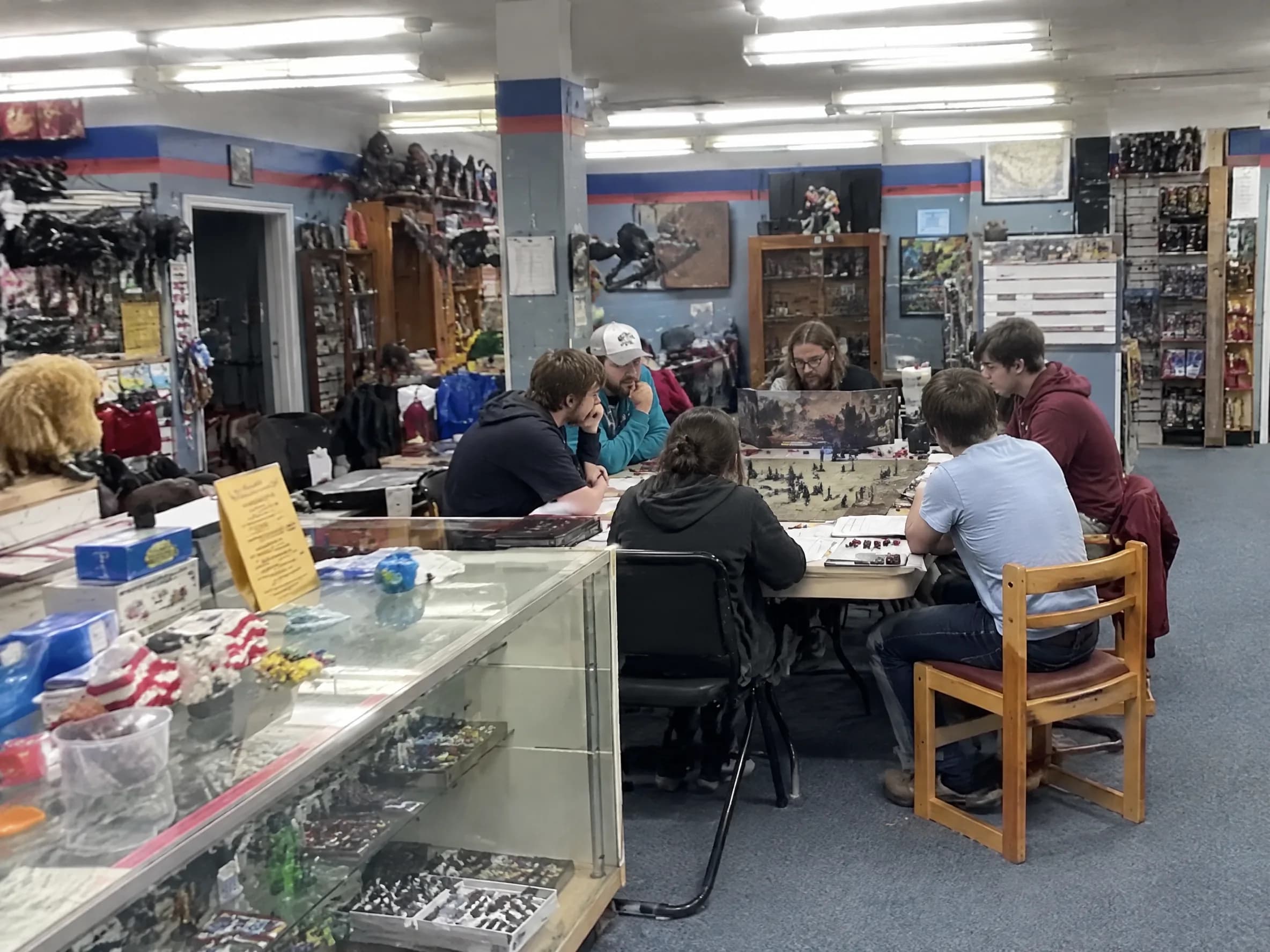 A D&D table with miniatures, dice, a map and a screen.